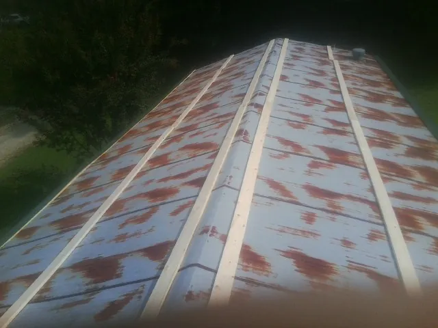 Rusted metal roof panels with new wood purlins before replacement — Storm Damage Roof Repair in Radford by Roofing Brothers