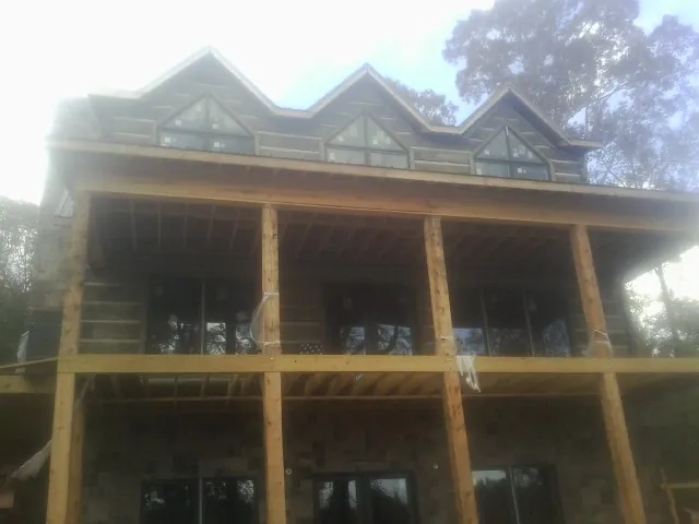 Dormers and porch framing on a large log home under construction — Roof Coating work by our crew in Radford
